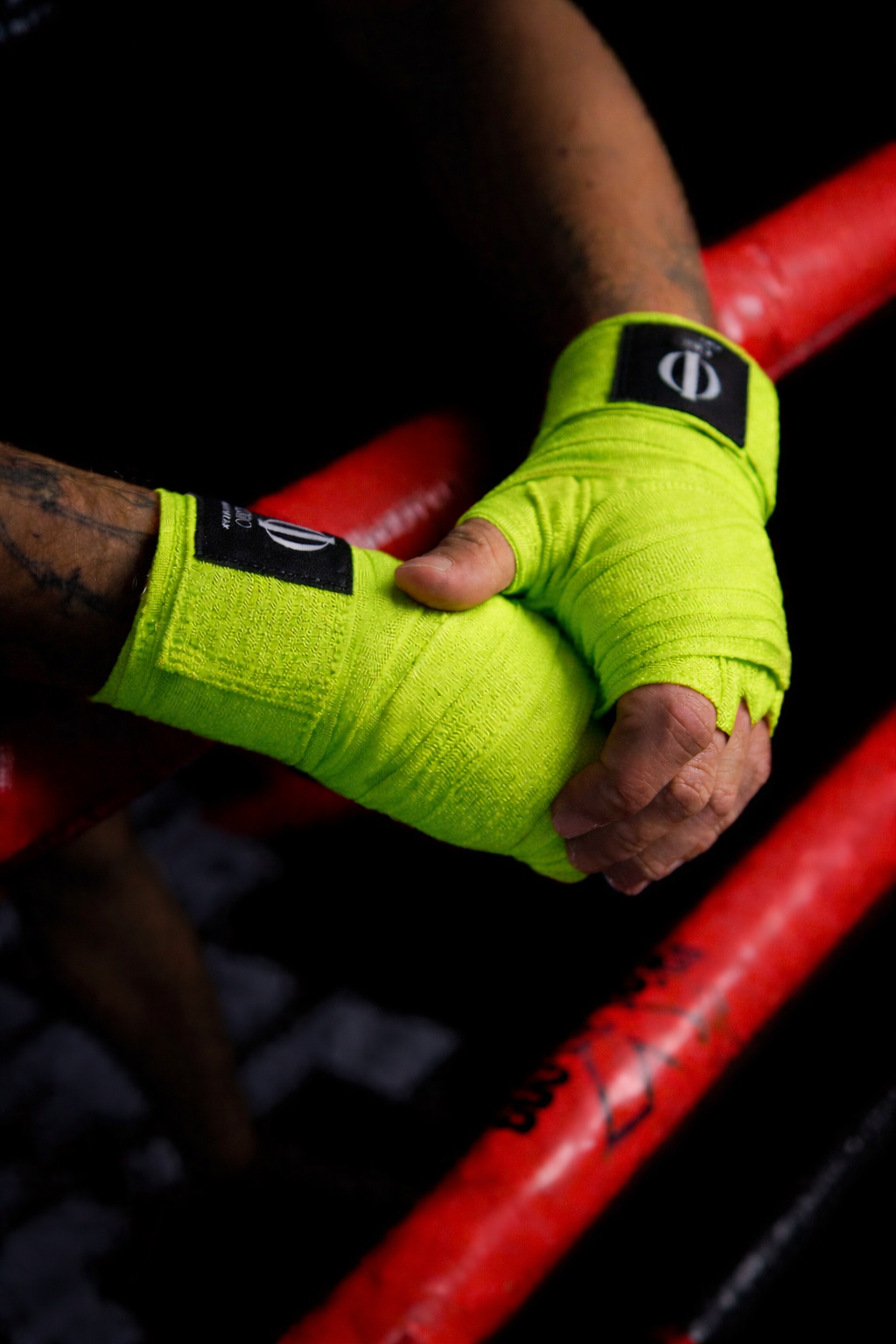 Manos con vendas Verdes ORO sobre las cuerdas del ring